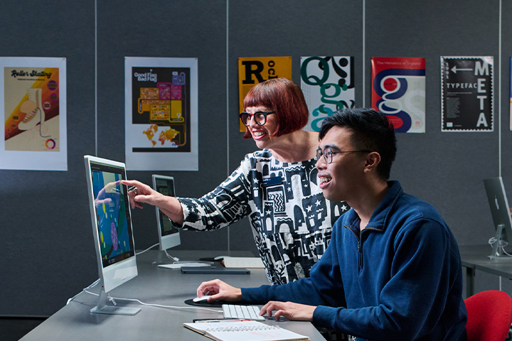 A young male student collaborates with his teacher on a design project, receiving guidance and feedback.