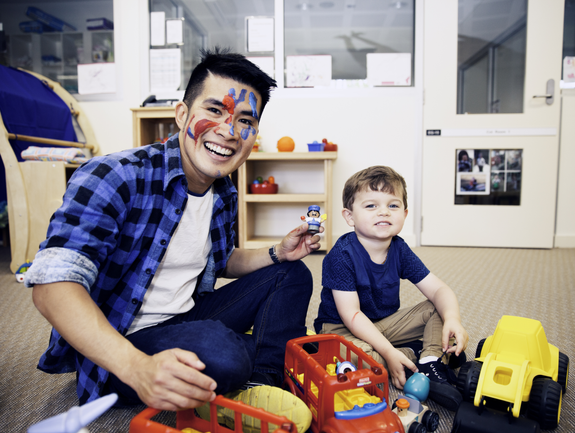 Early childhood education teacher engaging with young child in classroom.