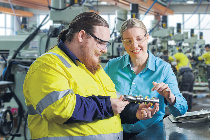 Student and teacher in a working factory