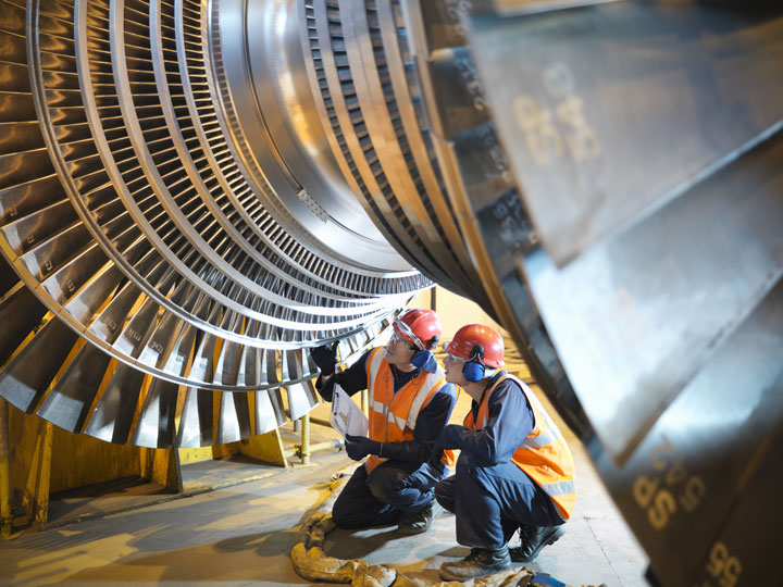 An aviation specialist and a learner inspecting a turbine. 