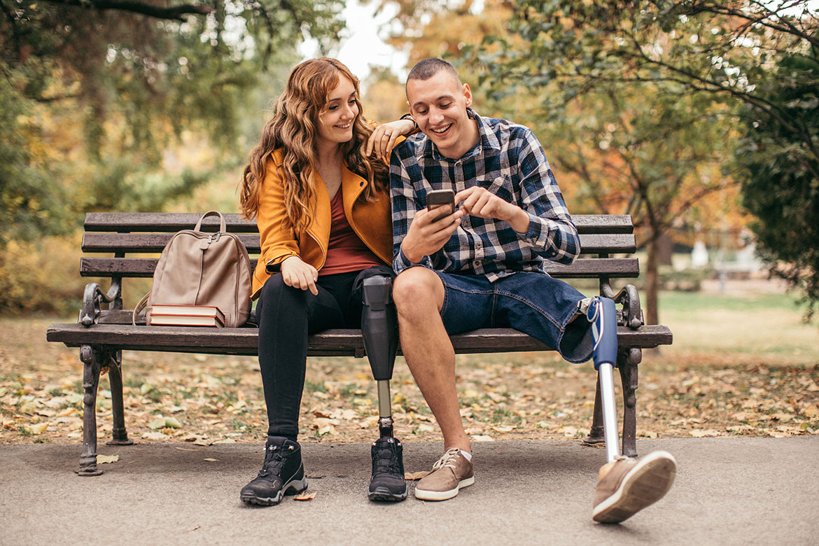 Disabled man sitting on a bench with a woman