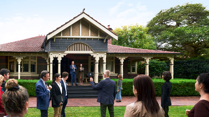 A traditional Australian home sits with a hedge lining the front porch. 