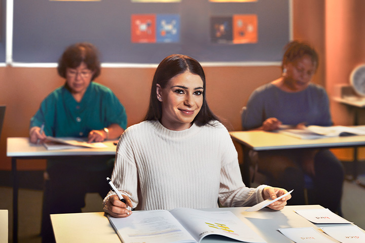 Student immersed in a diverse classroom environment, surrounded by peers, fostering a supportive atmosphere for language learning and communication skills development.