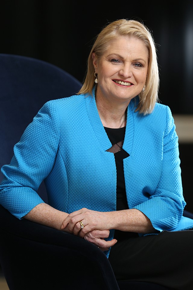 Katrina Troughton is smiling at the camera. She is wearing a bright blue jacket.