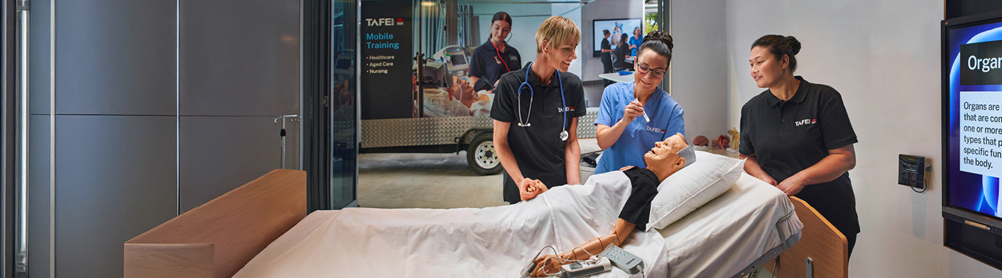 Aged care students practising caregiving techniques using a mannequin simulating real-world aged care scenarios in a portable learning environment