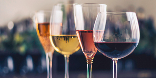 Four varieties of wine in glasses traditionally used for each. From front to back there’s a red wine, a fortified wine - butterscotch in colour, a white wine gold in colour, and a dessert wine that has a light orange colour.