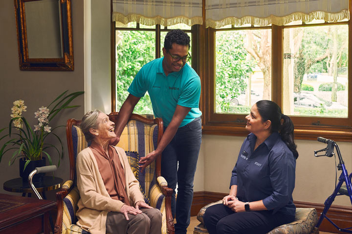 Compassionate young male aged care nurse providing attentive care to a resident