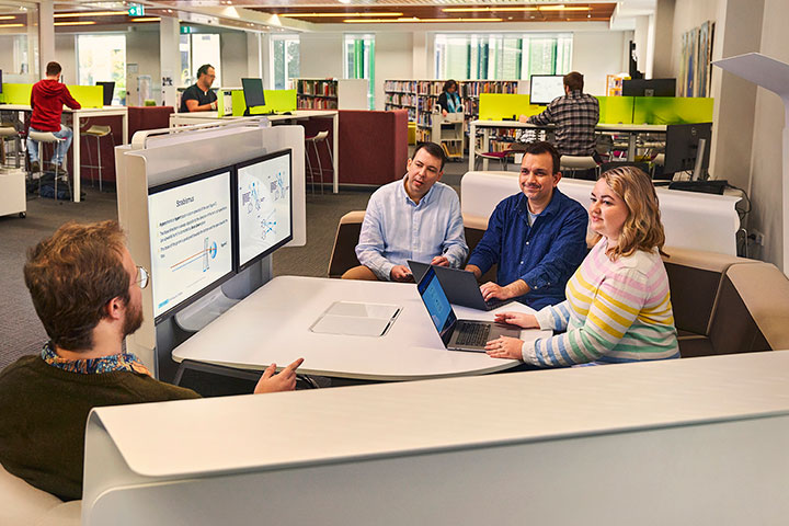 Collaborative discussion among adult students in a library pod setting.