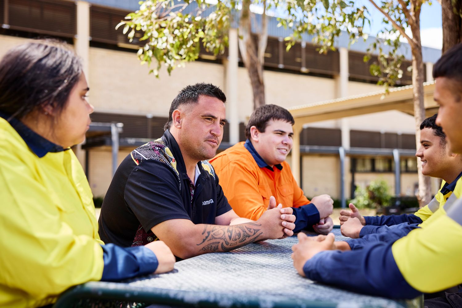 People sitting together and talking at an outdoor table.