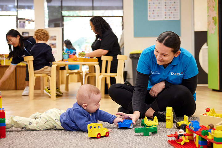 An early childhood education student engages in playful learning with a toddler.