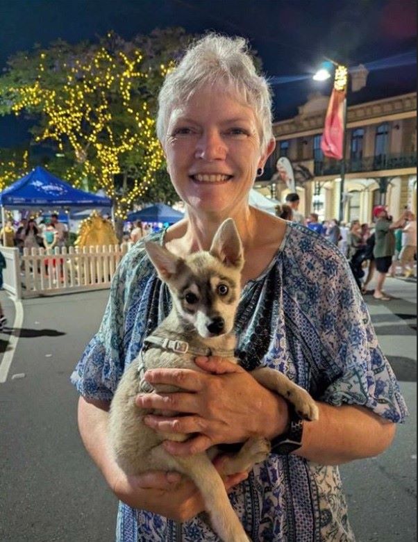 Cancer survivor Karrie Biggart holding a dog, embracing her new career as a vet nurse.