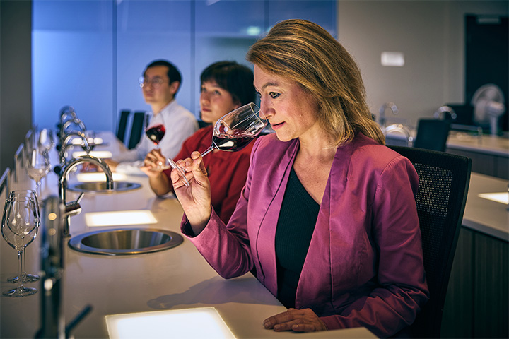 A lady smelling a red wine
